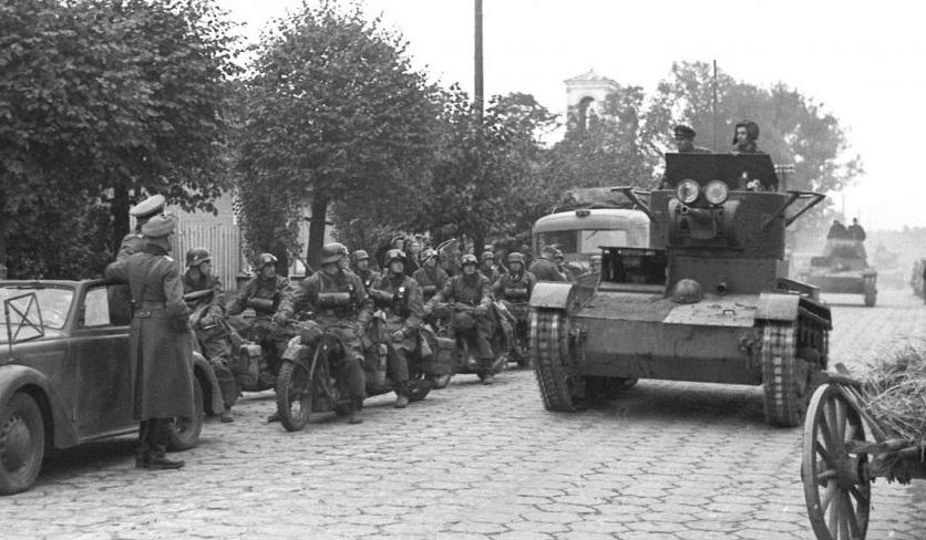 German motorcyclists giving a way to rolling Soviet tanks.